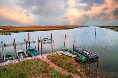 Chioggia, Venedik, Veneto, İtalya: güzel manzara lagününün yanında balıkçı tekneleri ve balık net beldesi gün batımında