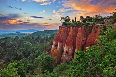 Roussillon, Provence, France: landscape at dawn of the reds ochre rocks and the green valley in the nature park of Luberon clipart