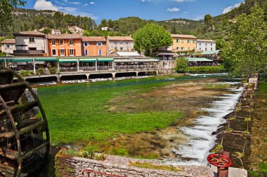 Fontaine-de-Vaucluse, Provence, France: landscape of the village that was the privileged stay of the poet Petrarch with the picturesque green Sorgue river clipart