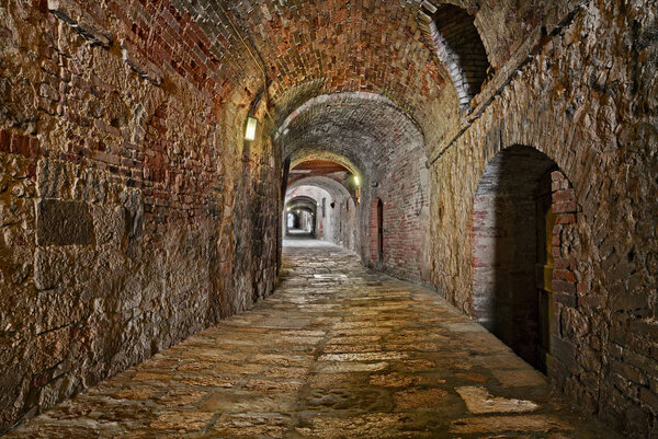 Colle di Val d'Elsa, Siena, Tuscany, Italy: the picturesque covered alley Via delle Volte, a medieval dark passage in the old town
