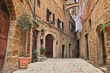 Volterra, Pisa, Tuscany, Italy: picturesque alley in the old town with ancient buildings and clothes hanging clipart