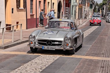 the former Formula 1 driver Jochen Mass and Artur Bechtel on Mercedes-benz 300 SL Coupe W198 (1955) in historical classic car race Mille Miglia, on May 19, 2017 in Gatteo, FC, Italy clipart