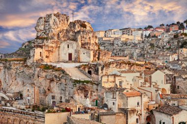 Matera, Basilicata, İtalya: peyzaj Santa Maria de Idris kaya Kilisesi ile eski şehir (sassi di Matera) gün batımında