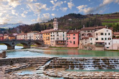 Santa Sofia, Forli Cesena, Emilia Romagna, Italy: landscape of the ancient town with the picturesque houses on the river shore and the Apennine mountains on background clipart