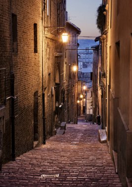 Jesi, Ancona, Marche, İtalya: Ortaçağ İtalyan şehrinin eski kasabasında gece manzaralı dar bir sokak 