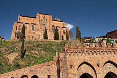 Siena, Tuscany, İtalya: San Domenico 'daki ortaçağ kilisesi Bazilikası' nın tarihi Fontebranda kaynağının üzerindeki tepenin manzarası