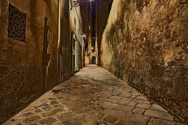 Florence, Tuscany, Italy: dark alley at night in the old town of the ancient Italian city