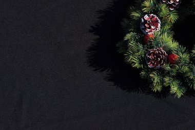 Selamlar ve metin için yer siyah zemin üzerine Noel çelenk.