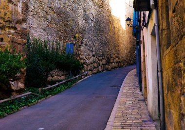 İspanya Tatil serisi. Tarragona dar sokakta. Sarı tuğla duvar ve taş döşeli kaldırım konuda seyahat, yaz, tatil.