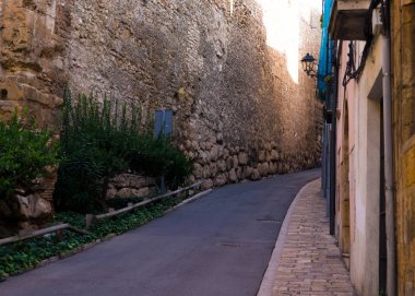 İspanya Tatil serisi. Tarragona dar sokakta. Sarı tuğla duvar ve taş döşeli kaldırım konuda seyahat, yaz, tatil.