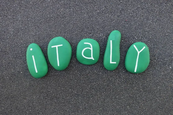 Italy, country name with green colored stonesover black volcanic sand
