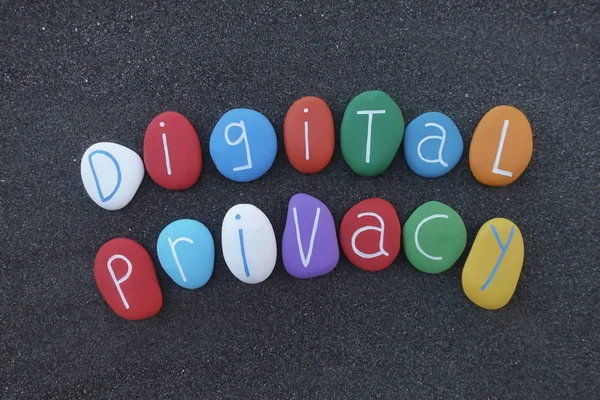Digital Privacy text composed with colored sea stones over black volcanic sand
