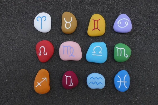 Astrological signs with stylized colored stones over black volcanic sand