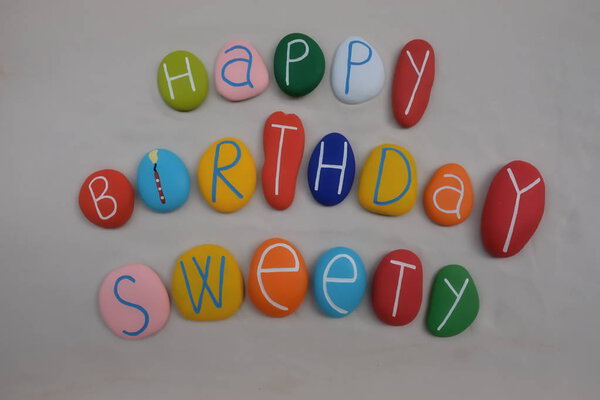 С днем рождения, сладкий, отмеченный цветными камнями на белом песке
