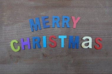 Renkli ahşap harf bileşimi ile neşeli Noel mesajı 