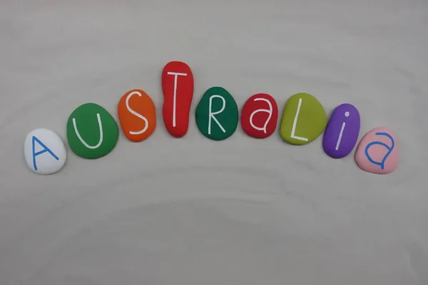 Australia, country name composed with colored sea stones over white sand