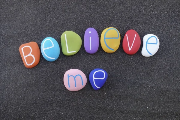 Believe me, motivational words composed with colored stones over black sand