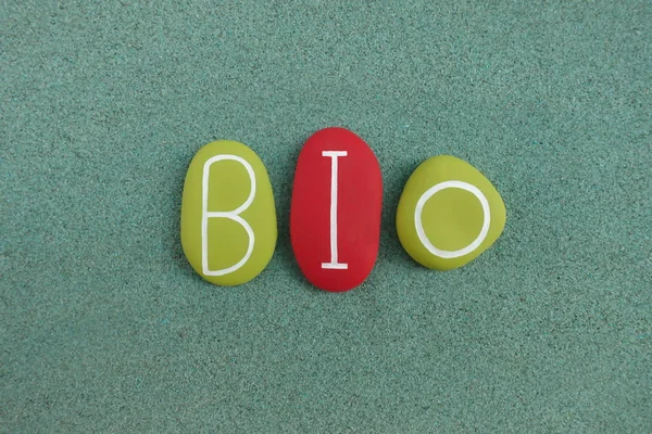 Bio text with green and red colored letters over green sand