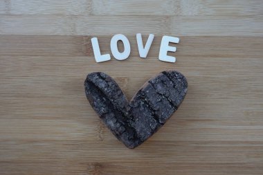 Ahşap harfler ve tahta bir kalple bestelenmiş metnini seviyorum.