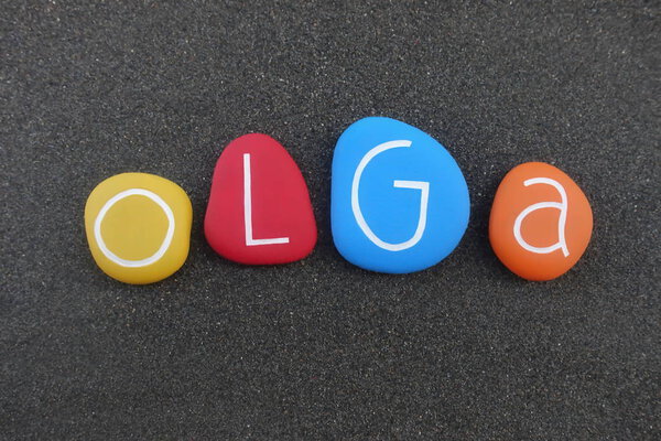 Ольга, женское имя составлено из разноцветных камней над черным вулканическим песком
