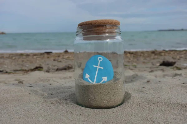 あなたは私のアンカーで ガラス瓶とビーチの背景に石と創造的な概念的な組成物です — ストック写真