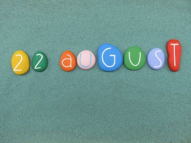 22 Ağustos, yeşil kum üzerinde çok renkli taşlarla oluşan takvim tarihi