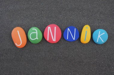 Jannik, erkek ismi siyah kumların üzerine çok renkli taşlar konmuş.