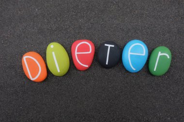 Dieter, erkeksi bir Alman ismi, Dietrich 'in kısa bir şekli, siyah volkanik kumların üzerinde çok renkli taşlar var.