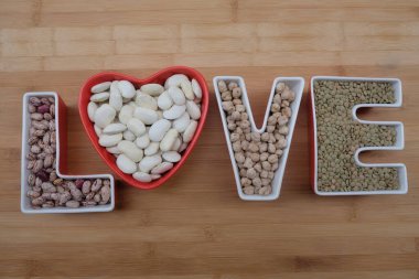Fasulye, mercimek ve nohut dolu seramik harflerle dolu aşk baklagilleri.