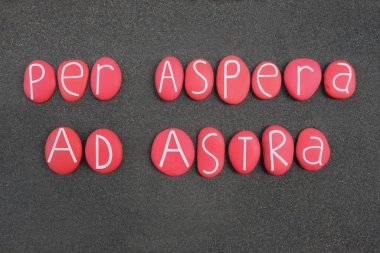 Per aspera ad astra, siyah volkanik kumların üzerine kırmızı renkli taş harflerle yazılmış Latince bir alıntı.