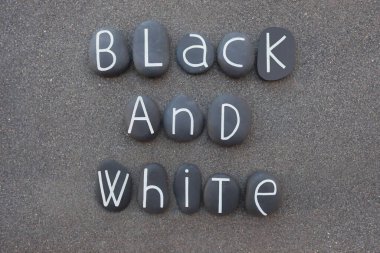 Siyah ve beyaz kavramları siyah volkanik kumların üzerinde boyalı taş harflerle oluşturulmuştur.