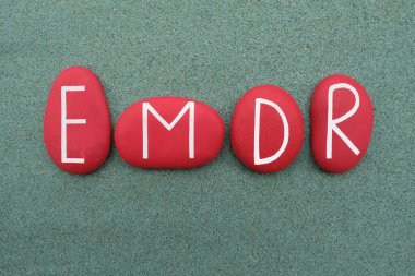 EMDR, Göz Hareketi Duyarsızlaştırma ve Yeniden İşleme, yeşil kum üzerinde kırmızı renkli taş harflerle oluşturulmuş yaratıcı metin