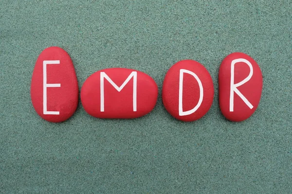 EMDR, Göz Hareketi Duyarsızlaştırma ve Yeniden İşleme, yeşil kum üzerinde kırmızı renkli taş harflerle oluşturulmuş yaratıcı metin
