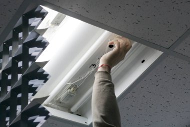 Bir elektrikçi denetlemek ve ışık onarmak için ofise geldi. arızalı parçaları değiştirme işlemi