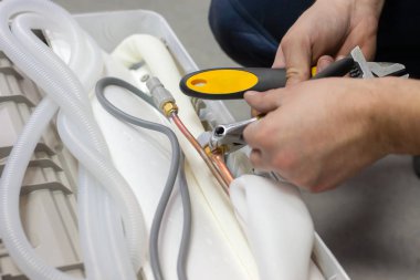 işçi Klima yüklemeye hazırlanılıyor. elinde çalışmak için araçlar. Gaz dolaşım tüpler temsilciliğin. tamir, bakım, Klima ofiste tanısında.