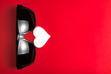 pembe kalpli kavramı güneş gözlüğü. moda komik tebrik kartı. kopya alanı. ilişkiler ve insanlar. sağlıklı bir yaşam tarzı. dekor ve tasarım için. kırmızı bir arka plan