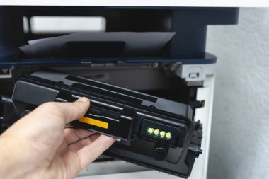 Fotokopi makinesi yedek toner kartuşu ile tamir teknisyeni ofis çalışanı. belgeleri yazdırmak için toner kartuş dolumu.
