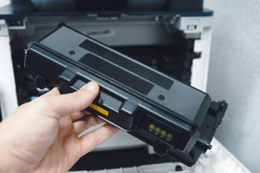 Fotokopi makinesi yedek toner kartuşu ile tamir teknisyeni ofis çalışanı. belgeleri yazdırmak için toner kartuş dolumu.