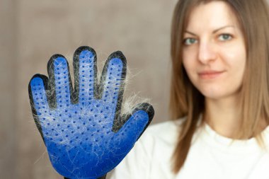 Dökülme, banyo, damat, eldiven deshedding kedi ile gülümseyen kız. Kediler kıllı eldiven. bakım aile içi evcil hayvanlar ve hayvanlar yün için donatım.