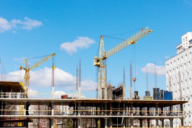 Apartman inşaatı. Mavi gökyüzünde endüstriyel turnalar