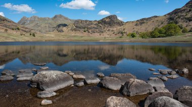 Sudaki Langdale turnalarının yansımaları ile Blean Tarn bir manzara görünümü. Blea Tarn, Lake District küçük tarns biri, Little Langdale Vadisi ve Dungeon Ghyll arasında büyük Langdale bir sırt kaplar. 