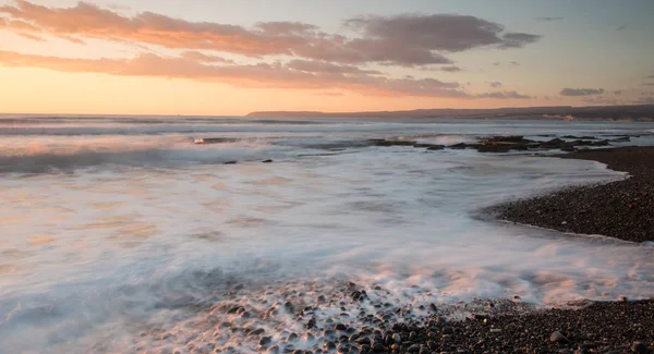 Limasol, Kıbrıs'taki Akrotiri bölgesinde kayalık bir kıyısında dramatik güzel gün batımı. Uzun pozlama fotoğraf