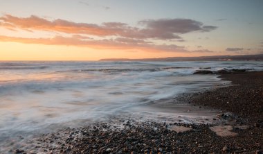 Limasol, Kıbrıs'taki Akrotiri bölgesinde kayalık bir kıyısında dramatik güzel gün batımı. Uzun pozlama fotoğraf