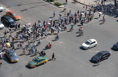 Bir grup insan bir yüksek trafik Caddesi ile otomobil ve bisiklet Çin Pekin şehir kapısı