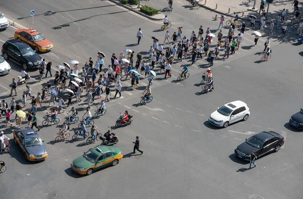 Bir grup insan bir yüksek trafik Caddesi ile otomobil ve bisiklet Çin Pekin şehir kapısı