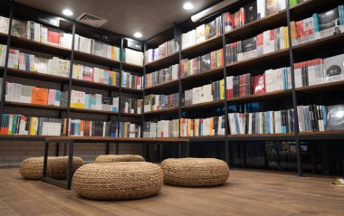  Okuma veya satın alma için çeşitli konularda kitap dolu raflar ile bir kitapçı kafe iç görünümü.