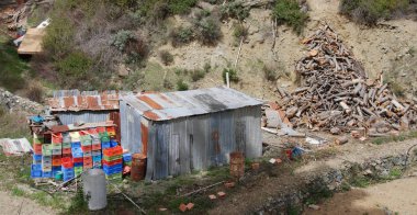 Meyve ve tarım araçları bir tepenin yamacında depolamak için metal depo
