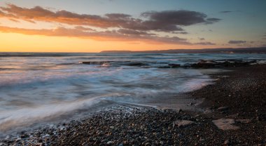 Limasol, Kıbrıs'taki Akrotiri bölgesinde kayalık bir kıyısında dramatik güzel gün batımı. Uzun pozlama fotoğraf