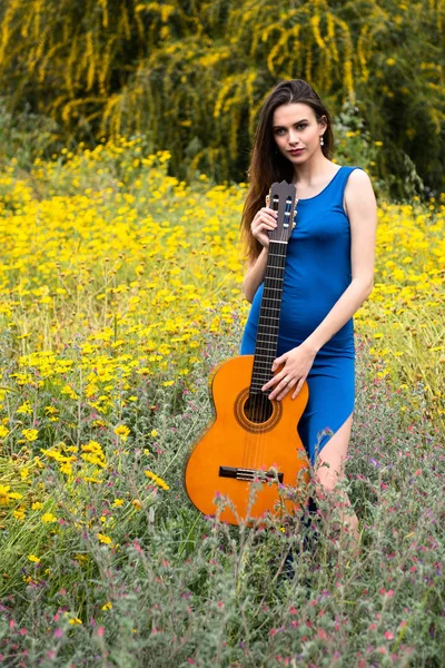 Atractiva joven hermosa mujer sosteniendo una guitarra clásica . —  Fotos de Stock