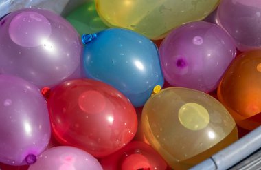 Su dolu bir sepetüzerinde renkli balonlar 